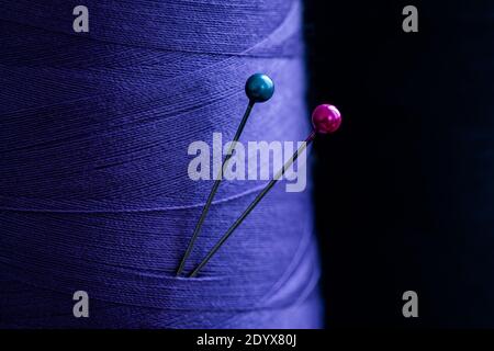 Nahaufnahme der Nähnadeln in blauem Tuch Stockfoto