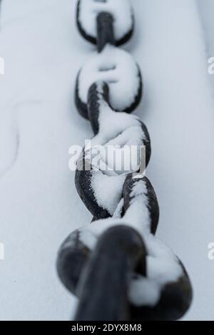 Gusseiserne Kette, ein Zaun unter dem Schnee. Das Winterkonzept ist gekommen. Es ist kalt. Hochwertige Fotos Stockfoto