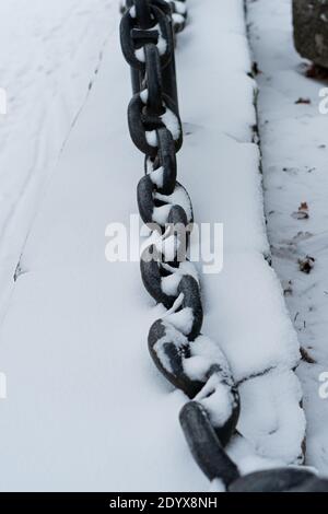 Gusseiserne Kette, ein Zaun unter dem Schnee. Das Winterkonzept ist gekommen. Es ist kalt. Hochwertige Fotos Stockfoto