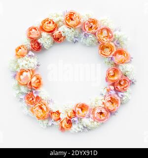 Flacher Blumenkranz mit Rosen und Hortensien in Orange mit Kopierraum. Schöner Kranz mit zarten orangen Rosen isoliert auf weißem Rücken Stockfoto