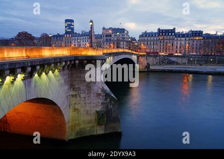 PARIS, FRANKREICH -15 DEZ 2020- Blick auf die Pont de la Tournelle, eine Bogenbrücke mit einer Skulptur von Sainte Genevieve, der schutzpatronin von Paris, über dem Stockfoto