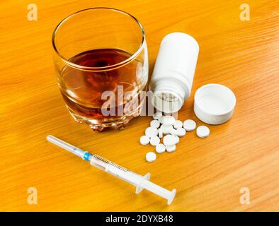 Glas des Whiskeys mit einem Pills und der Spritze Auf dem Tisch Nahaufnahme Stockfoto