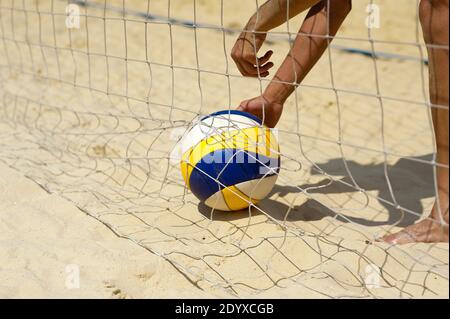 Beachvolleyball: Der Mann nimmt einen Ball auf Stockfoto