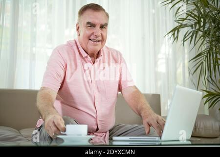 Leitender Mann, der an einem Laptop arbeitet Stockfoto