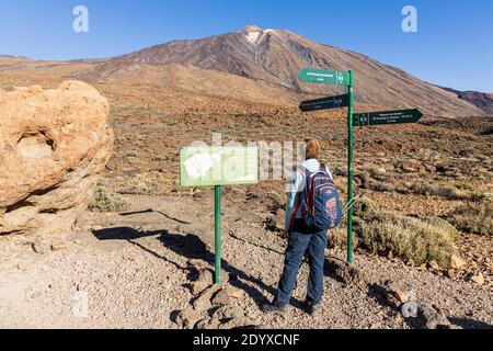 Wanderfrau bei Wegschildern und Weganweisungen auf Wanderwegen zum Pico Viejo im Nationalpark Las Canadas del Teide, Teneriffa, Kanarische Inseln, Spanien Stockfoto