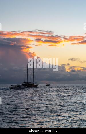 Holzschiff segelt mit Cumulonimbus Gewitterwolken und Sonnenuntergang im Hintergrund, Malediven. Stockfoto