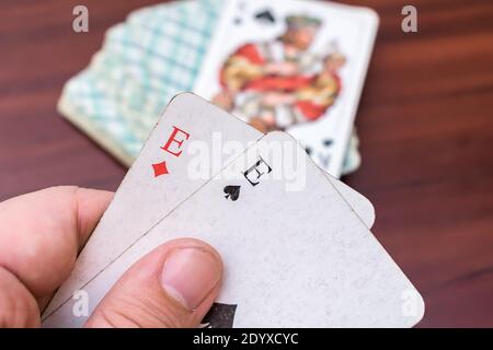 Mann hält Asse und Trümpfe in den Händen in einem Kartenspiel Stockfoto