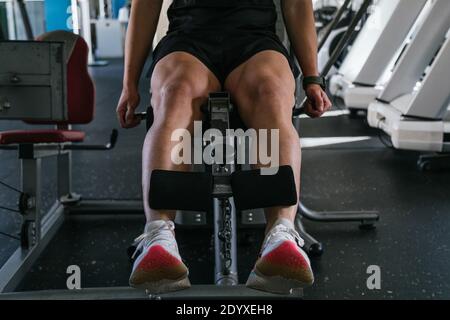 Gutaussehender Mann macht Beinübungen in einem Fitnessstudio. Nahaufnahme der Beine Stockfoto