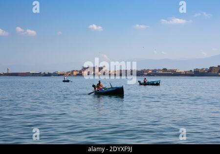 Sorrento, Italien - 2. Juli 2014: An einem klaren und sonnigen Sommertag steuern drei einheimische Fischer ihre Ruderboote in der Bucht von Neapel. Stockfoto