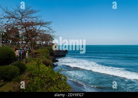 Touristen, die auf dem Weg am Meer bei Tanah Lot Tempel in Bali Stockfoto