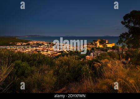 Blick über das Schloss, die Stadt und den Hafen von Castiglione della Pescaia und eine weitläufige Bucht der Maremma Küste bei Sonnenuntergang, Toskana, Italien Stockfoto