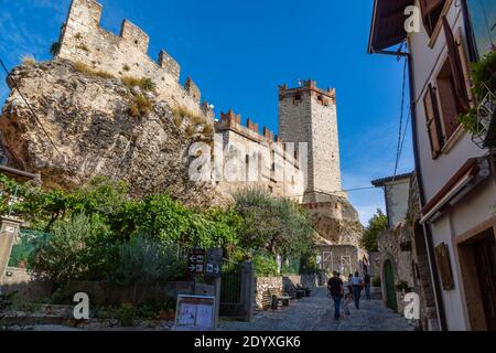 Blick auf Schloss und enge gepflasterte Straße an einem sonnigen Tag, Malcesine, Gardasee, Provinz Verona, Italien, Europa Stockfoto