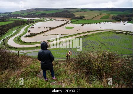 Alfriston Sussex UK 28. Dezember 2020 - EIN Wanderer hält an, um über Felder und Ackerland zu schauen, die vom Fluss Cuckmere in der Nähe von Alfriston in East Sussex überschwemmt werden, nachdem der kürzliche heftige Regen und Sturm Bella zu Störungen in ganz Großbritannien geführt hat. Mehr Schnee und Regen werden für Großbritannien in den nächsten Tagen prognostiziert : Credit Simon Dack / Alamy Live News Stockfoto