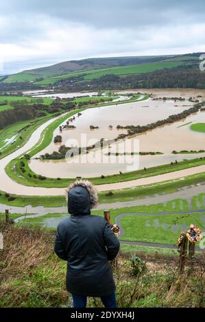 Alfriston Sussex UK 28. Dezember 2020 - EIN Wanderer hält an, um über Felder und Ackerland zu schauen, die vom Fluss Cuckmere in der Nähe von Alfriston in East Sussex überschwemmt werden, nachdem der kürzliche heftige Regen und Sturm Bella zu Störungen in ganz Großbritannien geführt hat. Mehr Schnee und Regen werden für Großbritannien in den nächsten Tagen prognostiziert : Credit Simon Dack / Alamy Live News Stockfoto