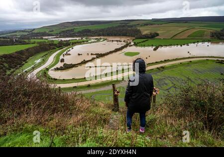 Alfriston Sussex UK 28. Dezember 2020 - EIN Wanderer hält an, um über Felder und Ackerland zu schauen, die vom Fluss Cuckmere in der Nähe von Alfriston in East Sussex überschwemmt werden, nachdem der kürzliche heftige Regen und Sturm Bella zu Störungen in ganz Großbritannien geführt hat. Mehr Schnee und Regen werden für Großbritannien in den nächsten Tagen prognostiziert : Credit Simon Dack / Alamy Live News Stockfoto