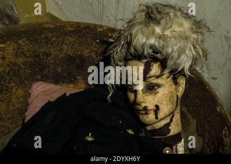Nahaufnahme einer gruseligen beschädigten gruseligen Schaufensterpuppe gegen eine Wand Stockfoto