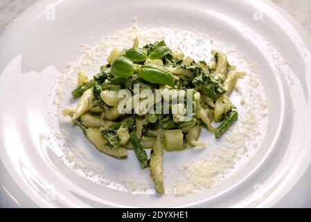 Trofie al Pesto - Italienische Pasta mit Basilikumpesto-Sauce, Kartoffeln und grünen Bohnen typisch für Genua, Ligurien, Italien - Nahaufnahme in weißem Gericht mit Rost Stockfoto