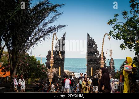 Muslimische und europäische Touristen, die durch den Tanah Lot Tempel spazieren Tor in Bali Stockfoto