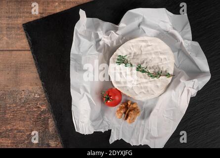 Köstlicher brie-käse auf schwarzem Hintergrund. Brie Käsesorte. Camembert. Frischer Brie-Käse und eine Scheibe auf Steinbrett. Italienischer, französischer Käse. Stockfoto