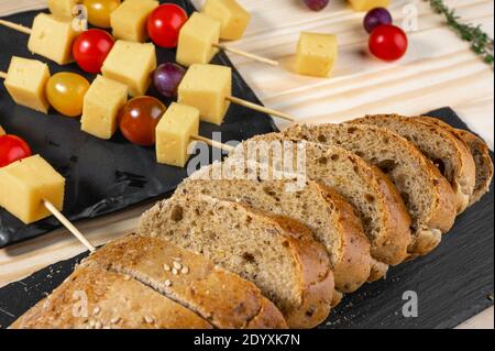 Brotscheiben und Snacks am Spieß. Canapes aus Oliven, Käse und Kirschtomaten auf Spieße. Fingerfood. Catering, Bankett. Nahaufnahme Stockfoto