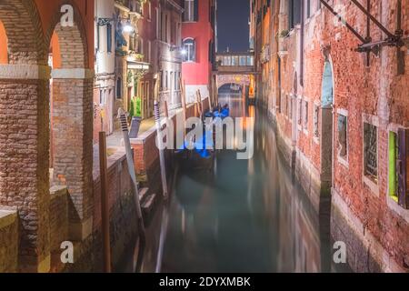 Eine ruhige venezianische Nacht, da Gondeln entlang eines Kanals in Venedig, Italien, parken Stockfoto