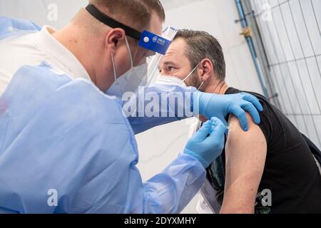 Bremen, Deutschland. Dezember 2020. Fabian Strader-saß, Krankenschwester, wird im Impfzentrum Bremen geimpft. Das Bremer Impfzentrum in der Messehalle 7 hat seinen Betrieb aufgenommen. Quelle: Sina Schuldt/dpa/Alamy Live News Stockfoto