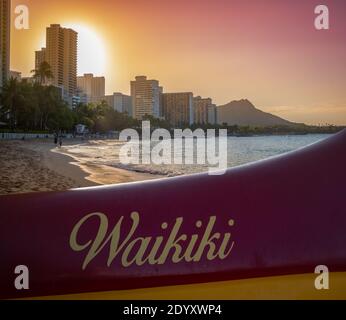 Ein traditionelles Hawaiian Outrigger Kanu am Waikiki Strand bei Sonnenuntergang Stockfoto
