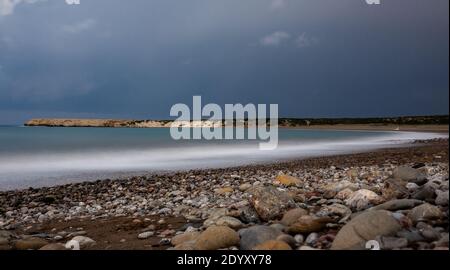 Sand- und Kieselstrand des Mittelmeers, nachts bei ruhigem Wetter mit langer Belichtung beschossen. Stockfoto