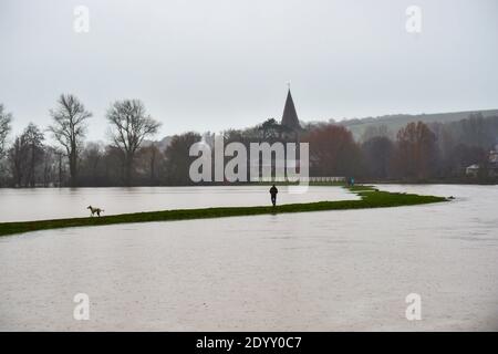 Alfriston Sussex UK 28. Dezember 2020 - Hundewanderer trotzen dem nassen Wetter, da Felder und Ackerland durch den Fluss Cuckmere in der Nähe von Alfriston in East Sussex überschwemmt werden, nachdem der kürzliche heftige Regen und Sturm Bella zu Störungen in ganz Großbritannien geführt hat. Mehr Schnee und Regen werden für Großbritannien in den nächsten Tagen prognostiziert : Credit Simon Dack / Alamy Live News Stockfoto