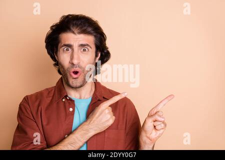 Nahaufnahme Porträt von schönen attraktiven gewunderten Kerl zeigt Kopieplatz Ad Pout Lippen isoliert über beige Pastellfarben Hintergrund Stockfoto