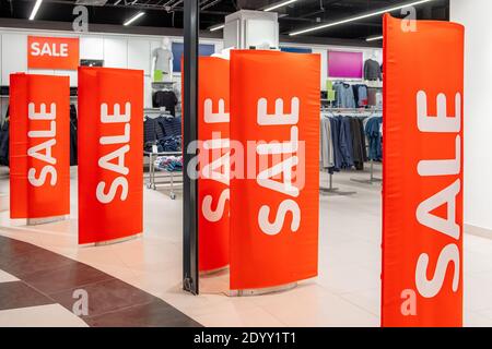 Rote Plakatwände am Eingang zum Bekleidungsgeschäft mit der Inschrift über den großen Saisonverkauf. Promotion, Werbung, Shopping und Black Frid Stockfoto