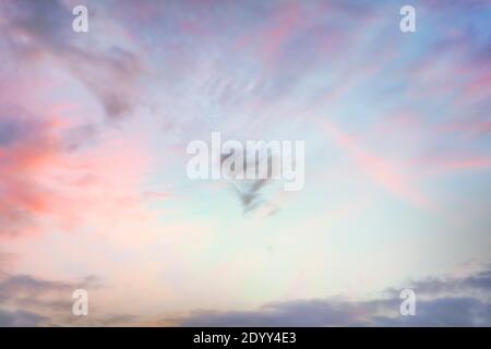 Herzförmige Wolke am Himmel bei Sonnenuntergang. Echte hochauflösende Fotografie Textur Hintergrund. Stockfoto