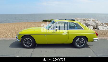 Classic Yellow MGB GT an der Strandpromenade geparkt. Stockfoto