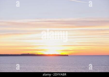 Hintergrund des schönen Winteruntergangs an der Adriaküste vor der blauen Adria in Slowenien. Stockfoto