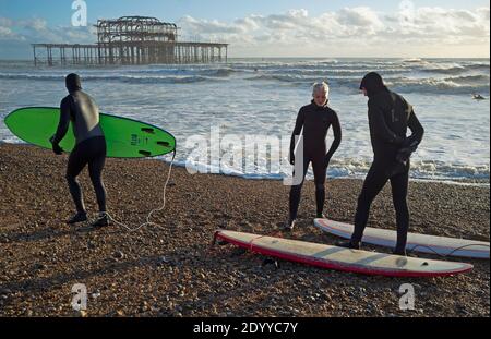 Surfer machen sich bereit, in das Meer auf einem zu gehen Wintertag in Brighton Stockfoto