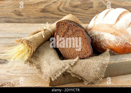 Arten von hausgemachtem Brot auf dem rustikalen Holztisch. Stockfoto