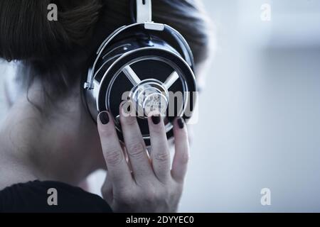 Rückansicht der Frau mit Vintage-Kopfhörer weißen Hintergrund. Stockfoto