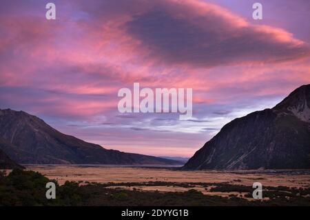 Lebendige Farben beleuchten die Wolken am Himmel über dem Hooker Valley im Mt Count National Park, Neuseeland bei Sonnenuntergang. Stockfoto