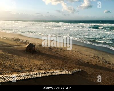 Die Treppe hinunter zu einem wunderschönen Strand in der Nähe Welliges Mittelmeer bei Sonnenuntergang Abendzeit in Skikda Algerien Stockfoto