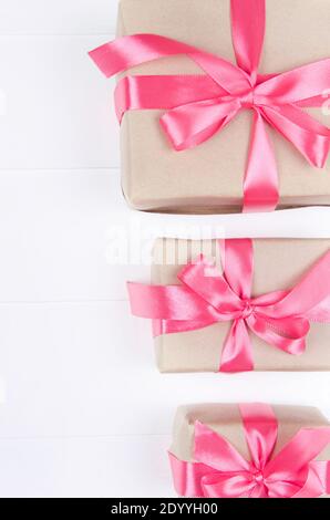 Geschenkboxen mit Schleife auf weißem Holzhintergrund. Valentinstag, Muttertag, 8. März, World Women's Day Feiertagskonzept. Stockfoto