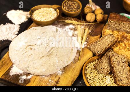 Hausgemachtes Vollkornbrot. Gesundes Gebäck. Rohstoffe für die Brotherstellung. Vollkornbrot auf dem Tisch. Stockfoto