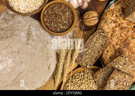 Hausgemachtes Vollkornbrot. Gesundes Gebäck. Rohstoffe für die Brotherstellung. Vollkornbrot auf dem Tisch. Stockfoto