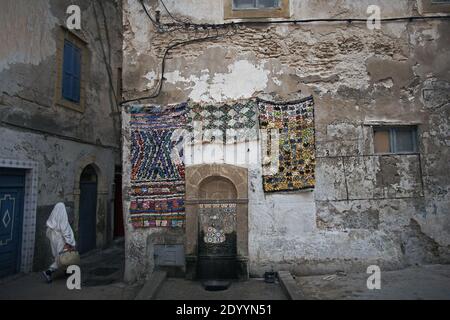 MAROKKO / Essaouira/ typisch marokkanische handgefertigte Teppichteppiche mit Kragen, die an der Wand in der Altstadt von Essaouira hängen. Stockfoto