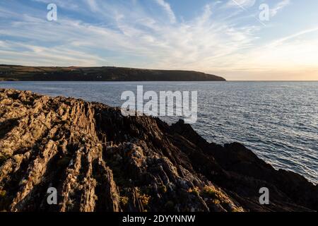 Cemaes Head von der Rocky Shore Line von Gwbert on Sea, Ceredigion, Wales aus gesehen Stockfoto