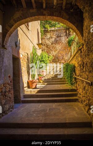 Ein Torbogen in einer Straße im historischen mittelalterlichen Dorf Batignano, Provinz Grosseto, Toskana, Italien Stockfoto