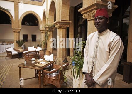 MAROKKO / Essaouira / Kellner wartet darauf, Sie in einem schönen Riad in der Medina von Essaouira begrüßt. Stockfoto