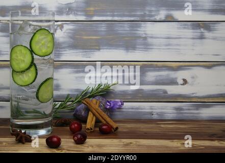 Nahaufnahme eines isolierten Cocktailglases mit Gin Tonic Gurkenscheiben, Zimt, Lavendel, Rosmarin, Cranberries Botanicals. Holzbretter mit Kopie-Spac Stockfoto