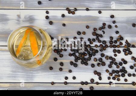 Blick von oben auf isoliertes Cocktailglas mit Gin Tonic Orangenscheiben und Wacholderbeeren auf weißen Holzplanken Tabelle Stockfoto