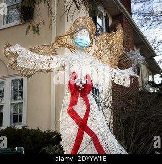 Ein Weihnachtshof Rasen Ornament eines Engels trägt ein Gesichtsmaske während der Covid 19 Pandemie von 2020 Stockfoto