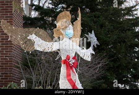 Ein Weihnachtshof Rasen Ornament eines Engels trägt ein Gesichtsmaske während der Covid 19 Pandemie von 2020 Stockfoto